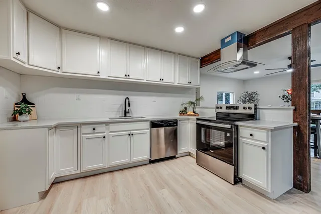 a kitchen with granite countertop a sink cabinets stainless steel appliances and a counter space