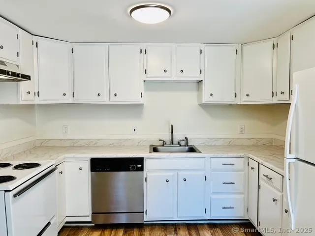 a kitchen with stainless steel appliances granite countertop white cabinets sink and dishwasher