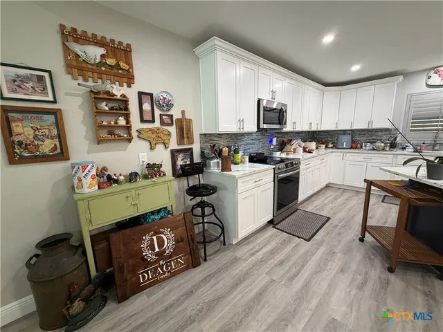a kitchen with a table chairs refrigerator and a sink