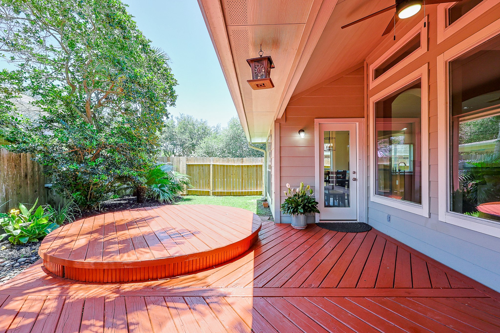 10306 Rudolph Court Missouri City, TX 77459 - Photo 28 of 34 This angle showcases more of the custom deck features of raised level circular deck, a chevron pattern deck plank layout and the lush tropical landscaping.