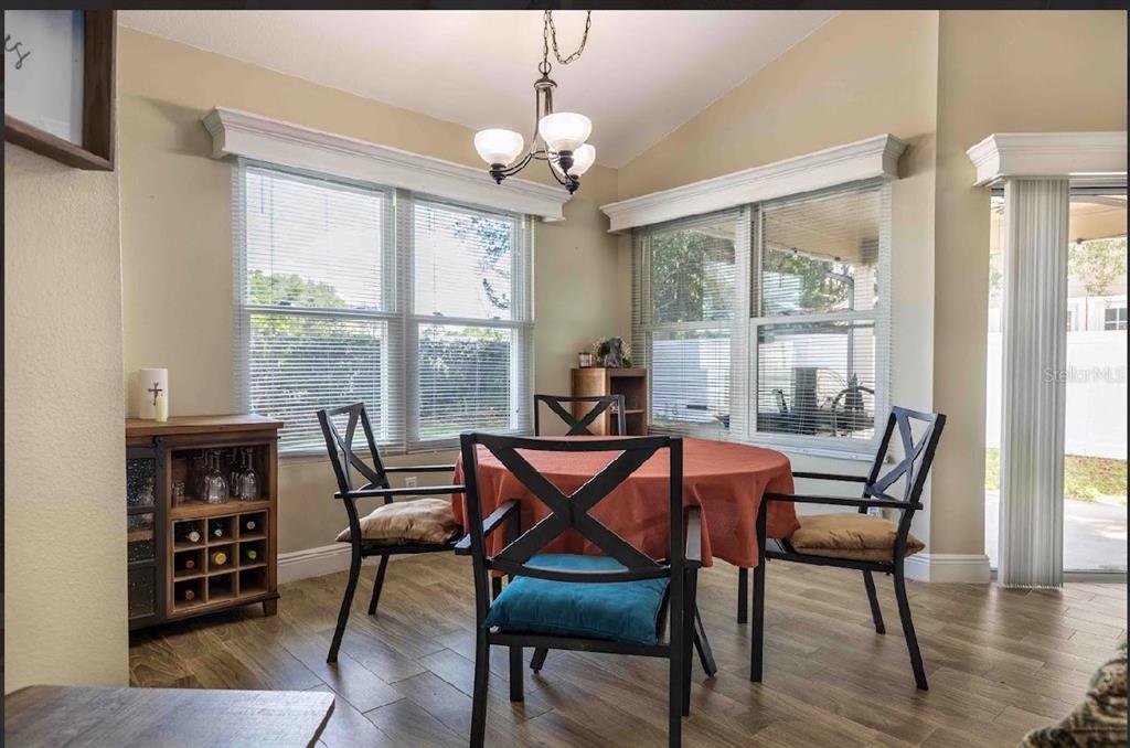 10665 Huntridge Road Orlando, FL 32825 - Photo 6 of 12 a dining room with furniture a chandelier and wooden floor