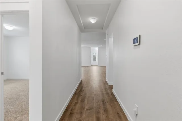 a view of a hallway with wooden floor