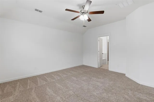 an empty room with a fan & a ceiling fan