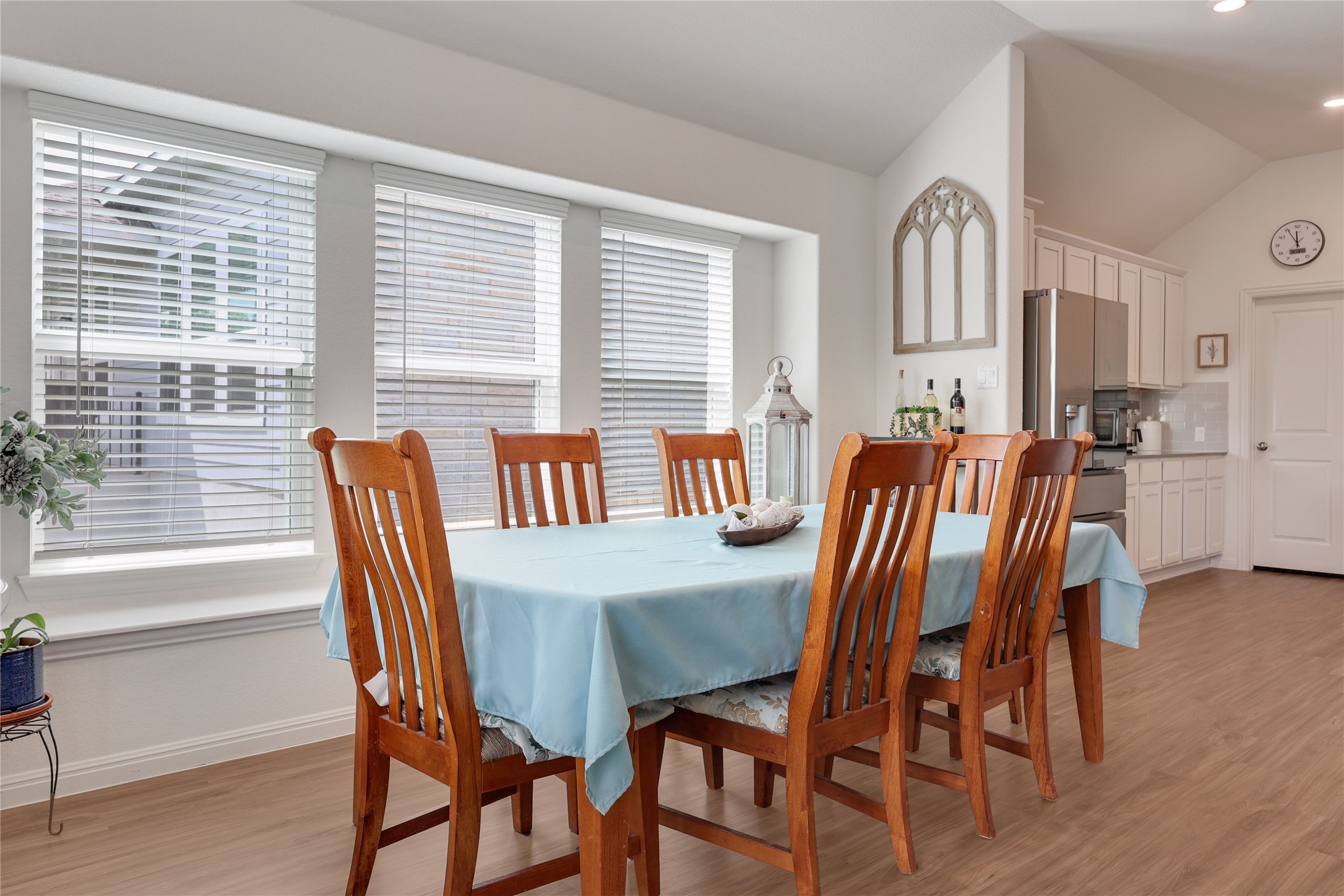 240 Prato Place Georgetown, TX 78628 - Photo 13 of 40 The dining area features large windows with blinds, wood-style flooring, and a vaulted ceiling