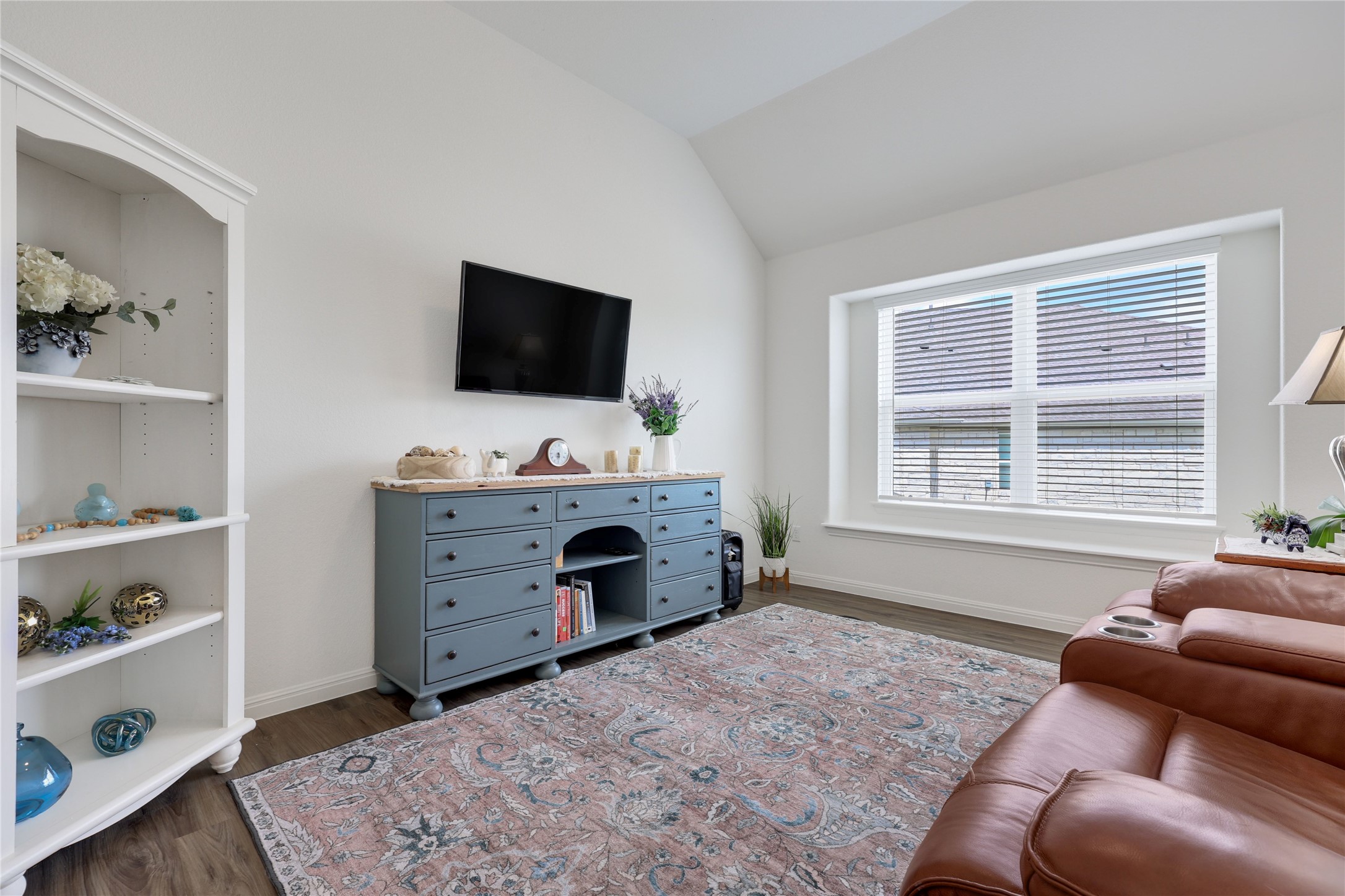 240 Prato Place Georgetown, TX 78628 - Photo 15 of 40 Living area featuring a large window with blinds, vaulted ceilings, and dark wood-style flooring