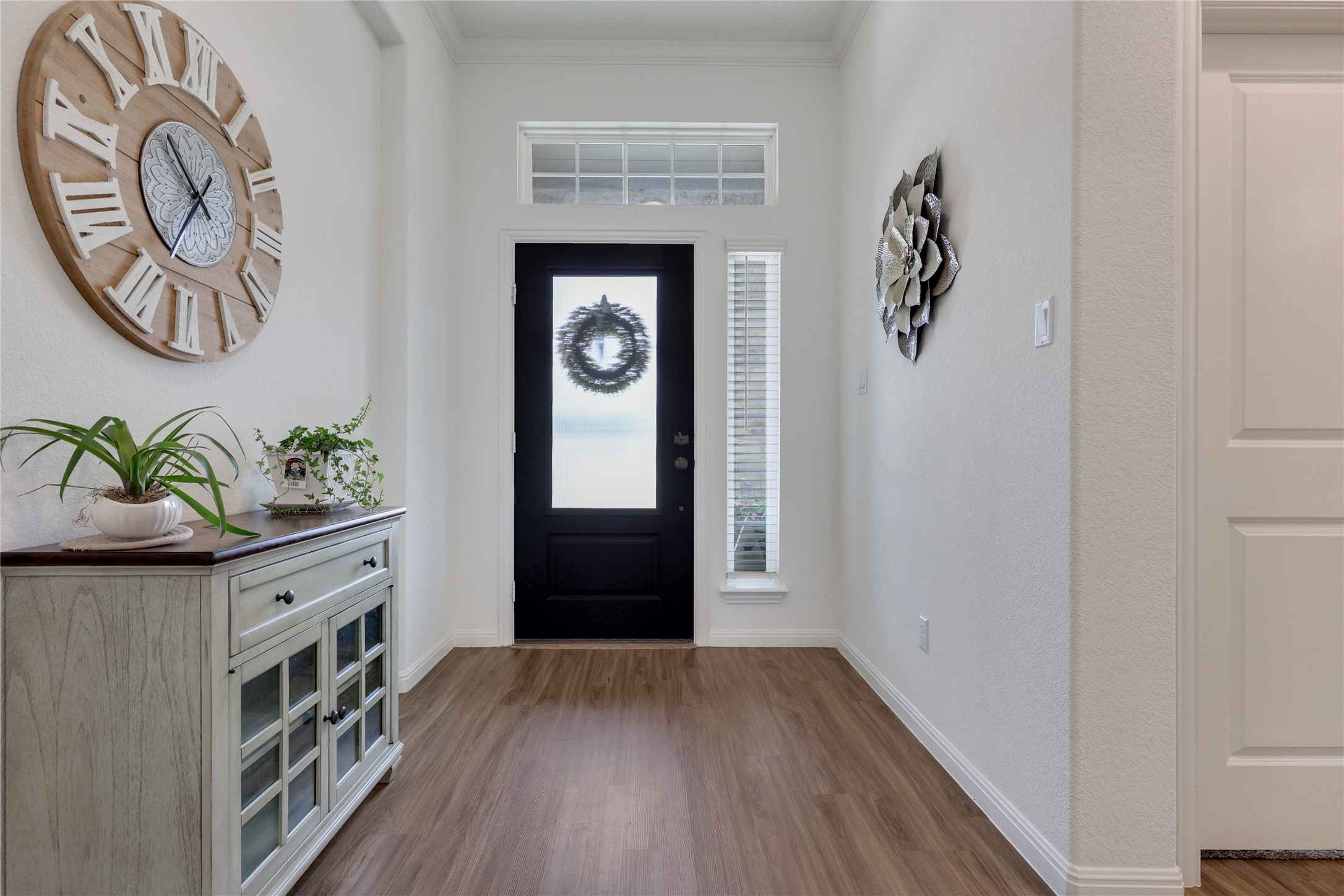 240 Prato Place Georgetown, TX 78628 - Photo 2 of 40 Entryway featuring wood-look flooring, a dark entry door with frosted glass, and a transom window