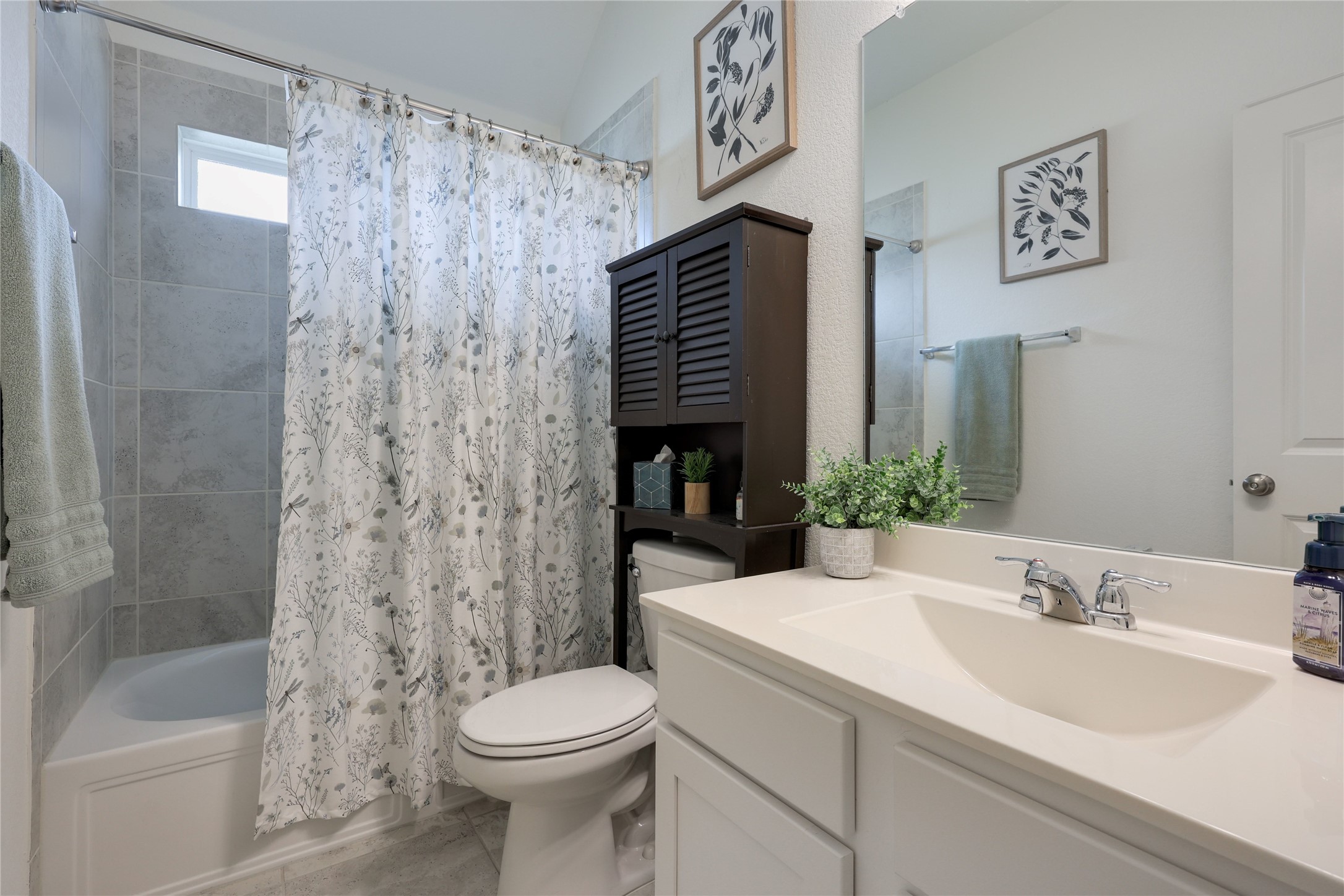 240 Prato Place Georgetown, TX 78628 - Photo 28 of 40 This bathroom features a bathtub with light gray tiled walls and a shower curtain