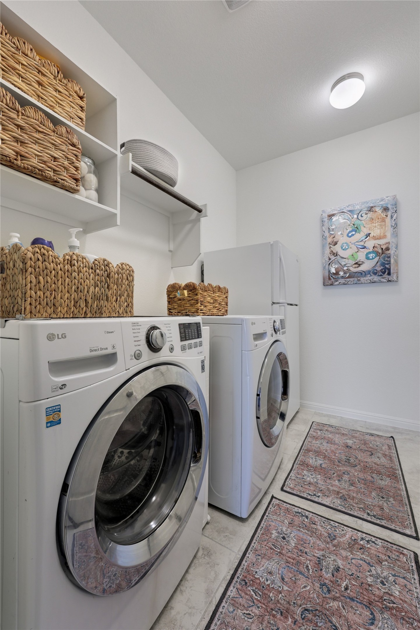 240 Prato Place Georgetown, TX 78628 - Photo 30 of 40 The property includes a dedicated laundry room with a washer and dryer, complemented by overhead shelving for storage