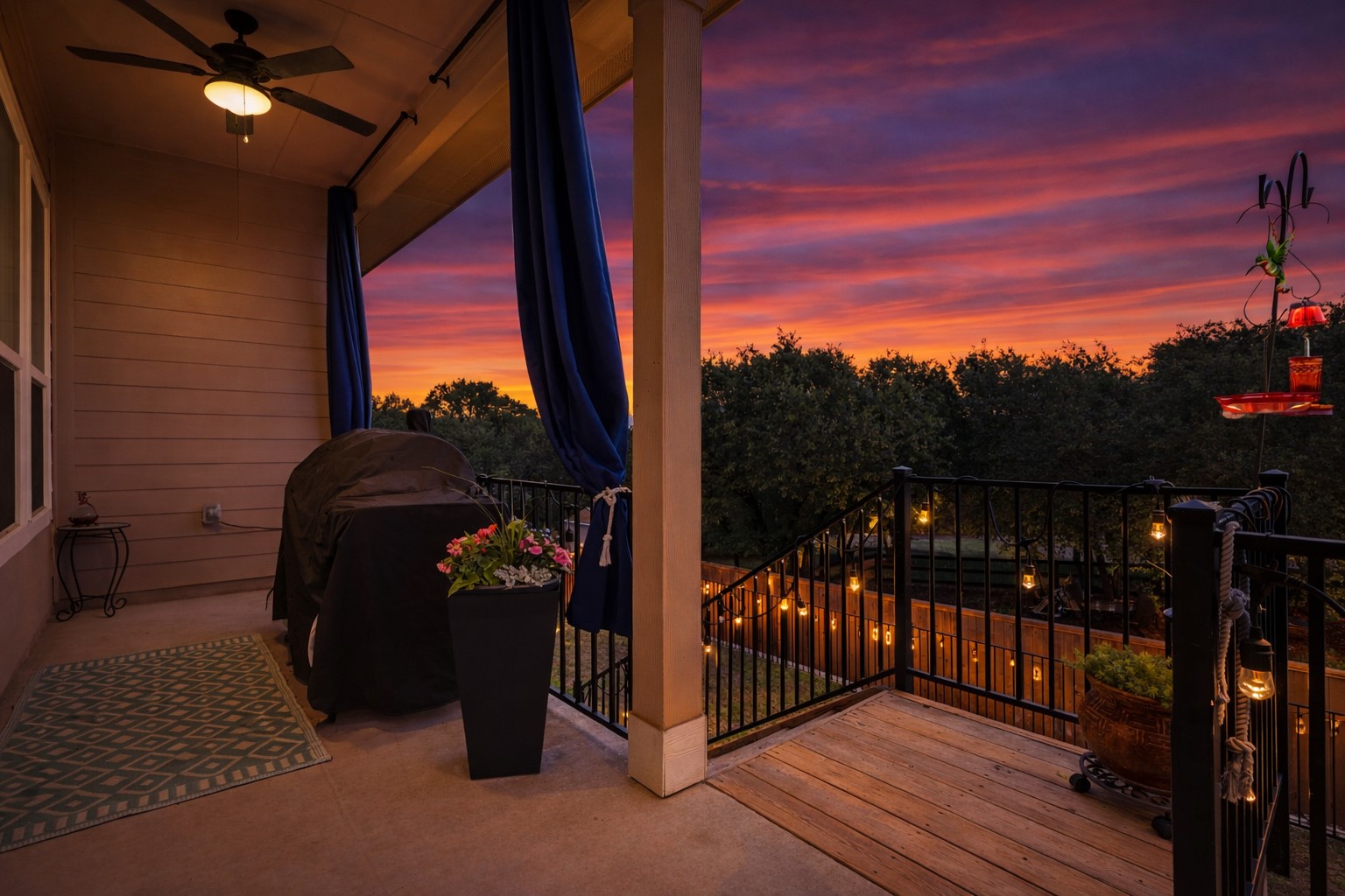 240 Prato Place Georgetown, TX 78628 - Photo 33 of 40 AI Twilight-The property features a covered patio with a ceiling fan, offering an outdoor living space with a railing, and a view of trees and the sky