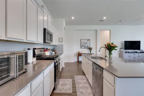 a large kitchen with stainless steel appliances granite countertop a lot of counter space and a sink