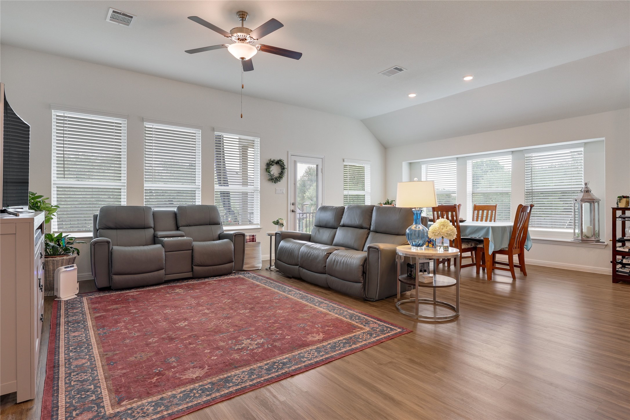 240 Prato Place Georgetown, TX 78628 - Photo 10 of 40 Spacious open-concept living area featuring wood-look flooring, ample natural light from multiple windows, and a ceiling fan