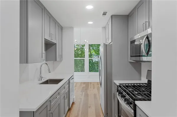a kitchen with stainless steel appliances a sink stove and cabinets