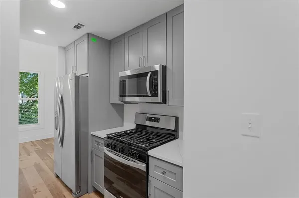 a kitchen with stainless steel appliances a stove a microwave and a refrigerator