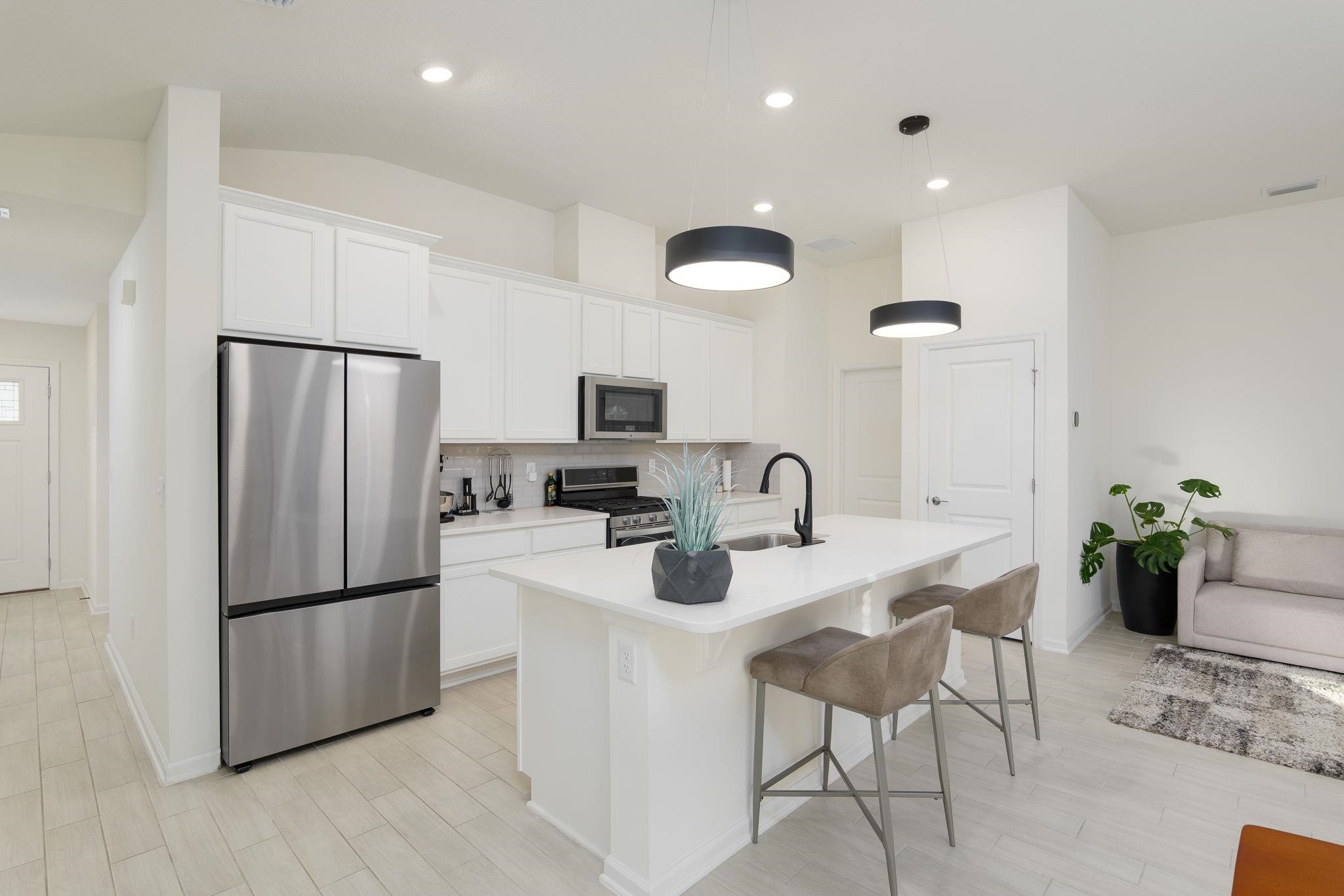 28 Peace River Road St. Johns, FL 32259 - Photo 2 of 41 a kitchen with stainless steel appliances granite countertop a refrigerator a sink a stove a dining table and chairs