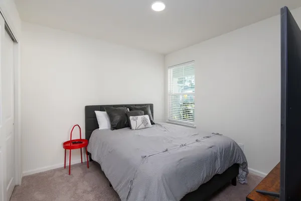a bedroom with a bed and a lamp next to a window