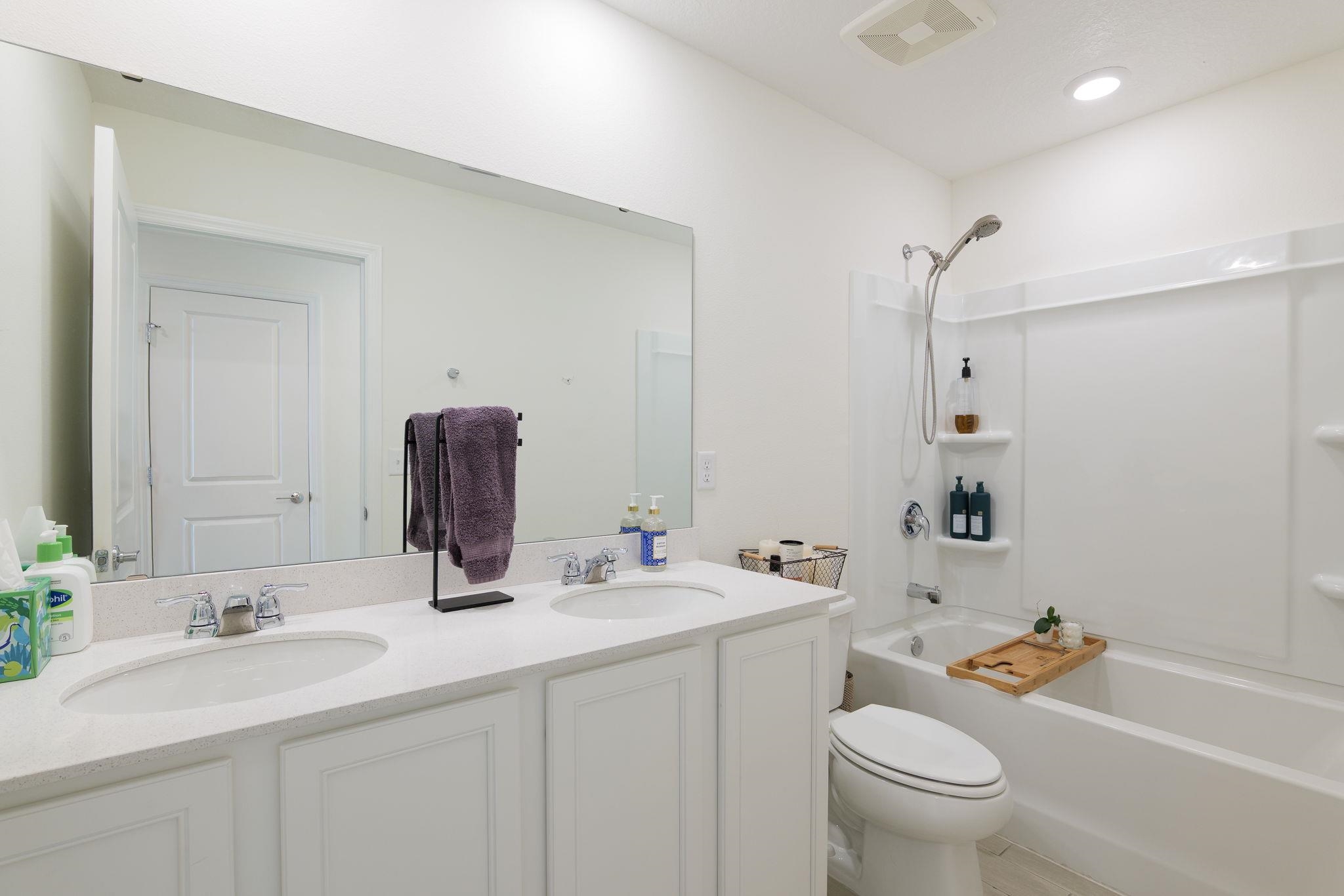 28 Peace River Road St. Johns, FL 32259 - Photo 22 of 42 a bathroom with a double vanity sink toilet mirror and shower