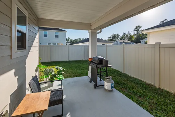 a view of a chair and table in backyard of the house