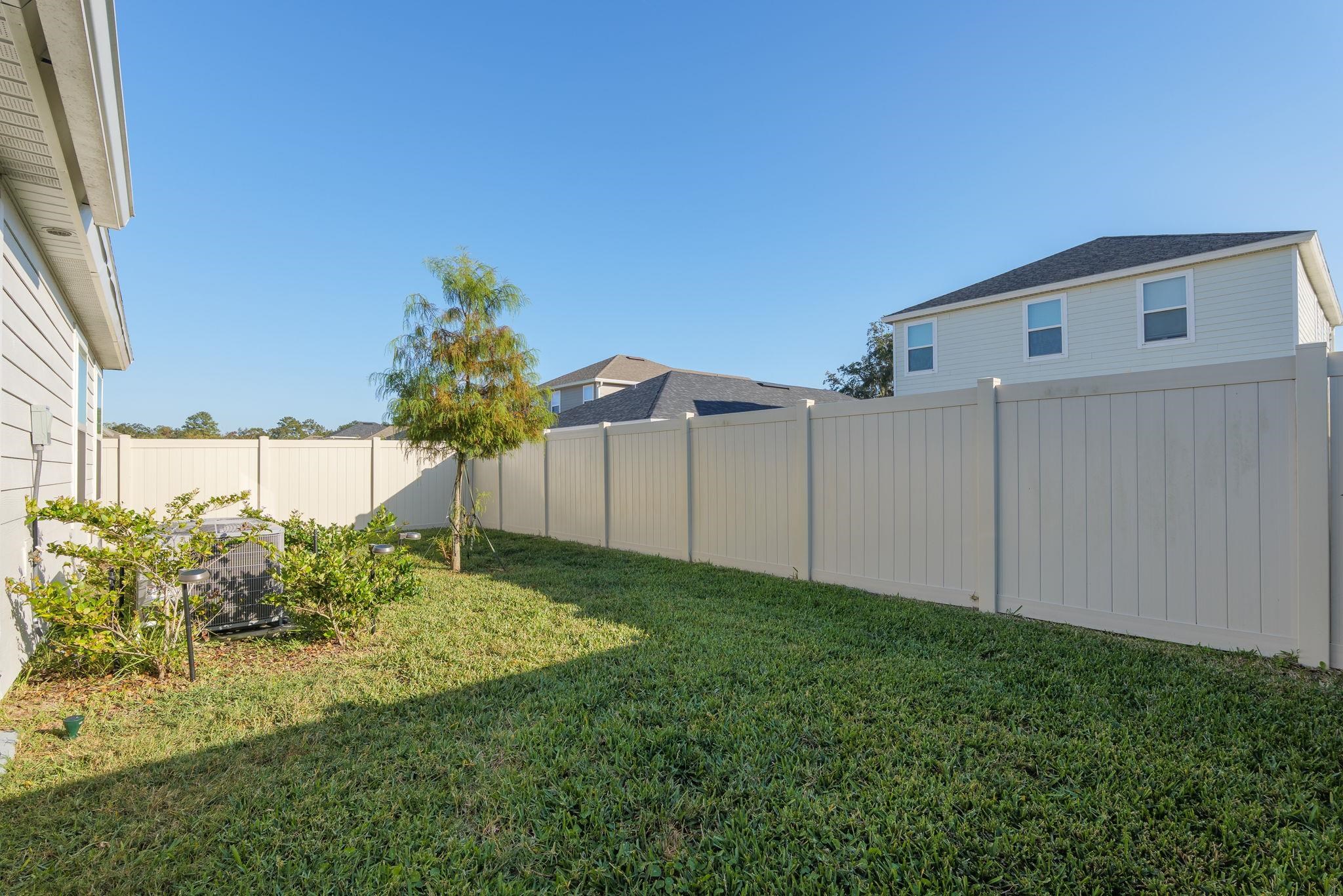 28 Peace River Road St. Johns, FL 32259 - Photo 31 of 42 a backyard of a house with plants and wooden fence