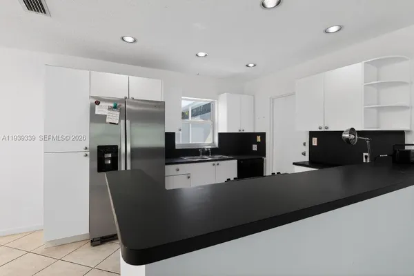 a kitchen with stainless steel appliances granite countertop a refrigerator a stove a sink and a refrigerator