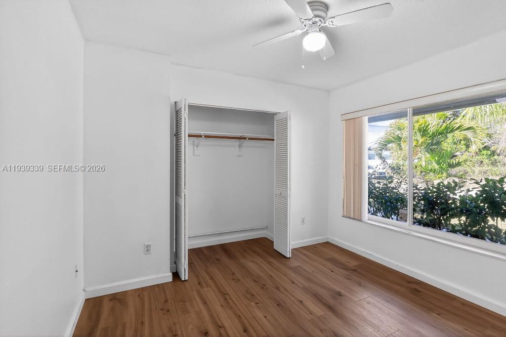 9900 Southwest 164th Terrace Miami, FL 33157 - Photo 22 of 44 an empty room with wooden floor fan and windows