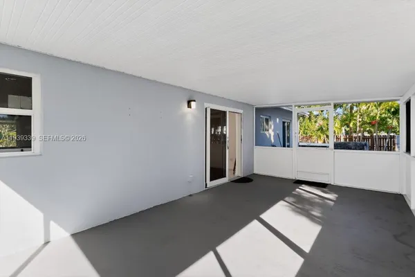 a view of an empty room with closet and a window
