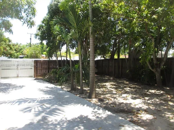 a white house that has tree in front of it