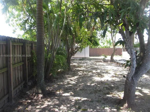 a view of a yard with plants and trees