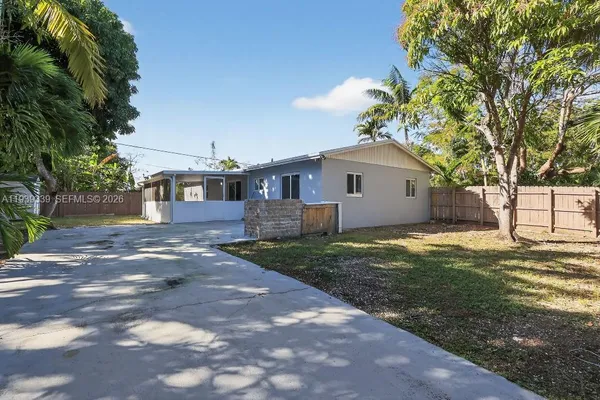 a front view of a house with a garden and trees