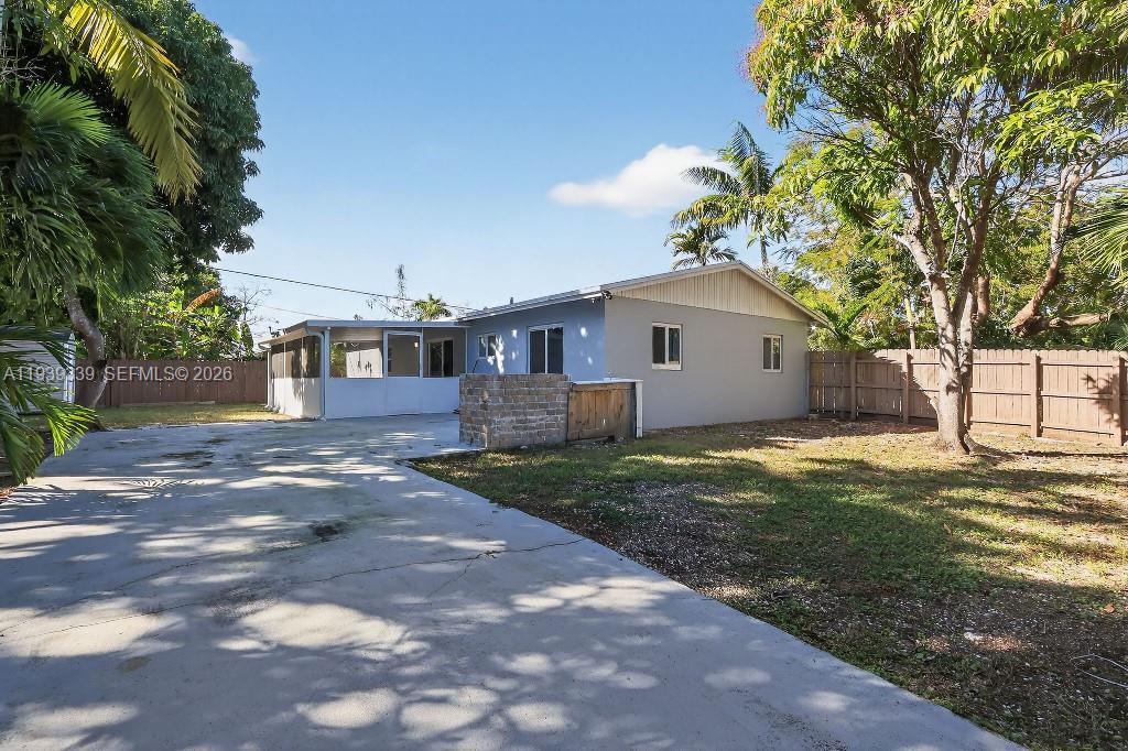 9900 Southwest 164th Terrace Miami, FL 33157 - Photo 5 of 44 a front view of a house with a garden and trees