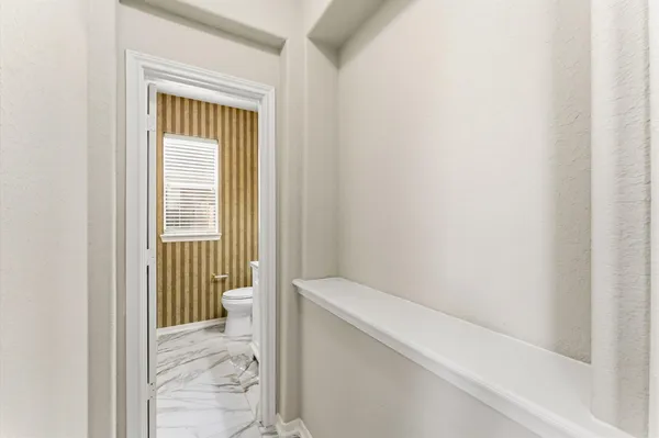 a view of a hallway with a white walls and a window