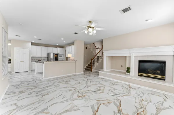 a view of an empty room with chandelier fan