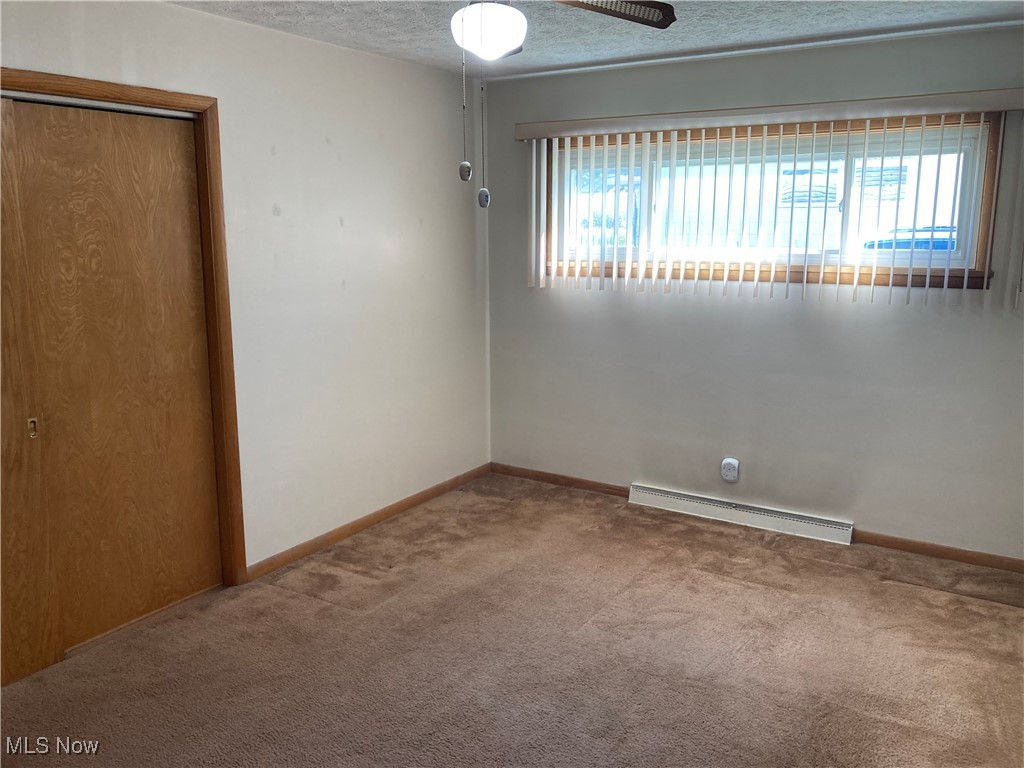 2547 Mayfair Road Akron, OH 44312 - Photo 23 of 50 Carpeted spare room with a baseboard heating unit, a textured ceiling, and ceiling fan
