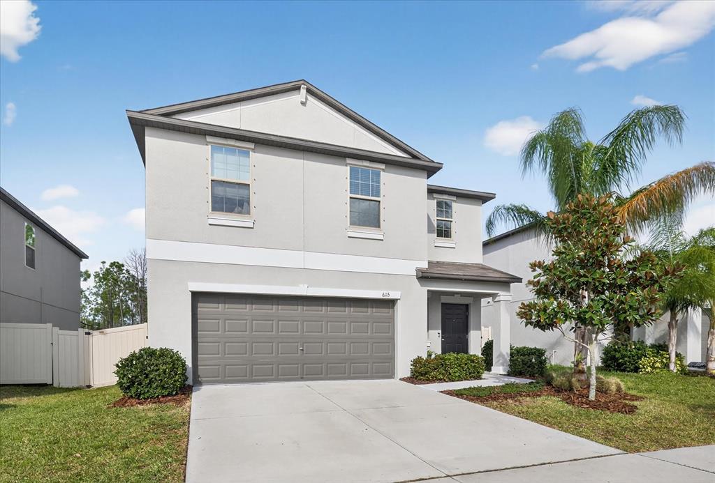 6115 Apple Snail Avenue New Port Richey, FL 34653 - Photo 32 of 59 a front view of a house with a yard and garage