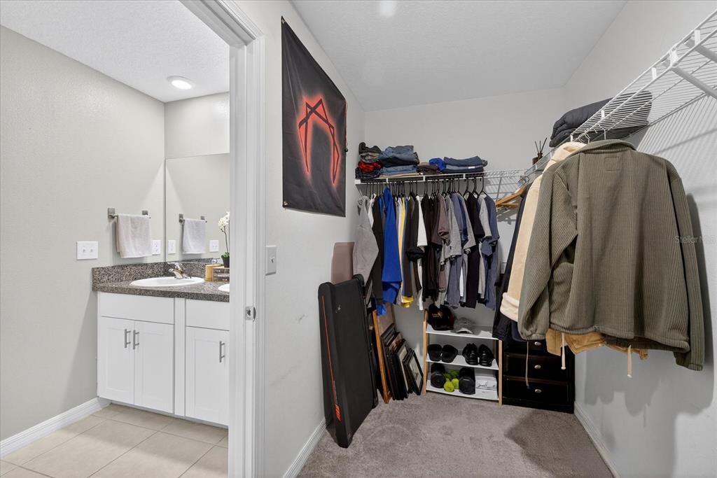 6115 Apple Snail Avenue New Port Richey, FL 34653 - Photo 40 of 59 a view of walk in closet with clothes and shoes