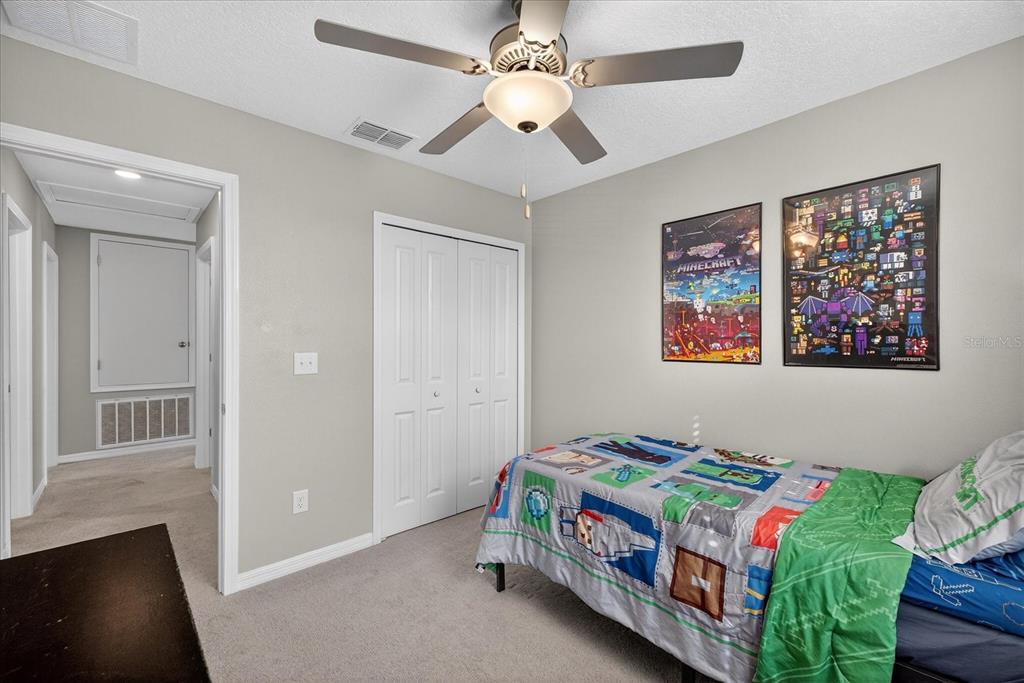 6115 Apple Snail Avenue New Port Richey, FL 34653 - Photo 44 of 59 a bedroom with a bed and a chandelier