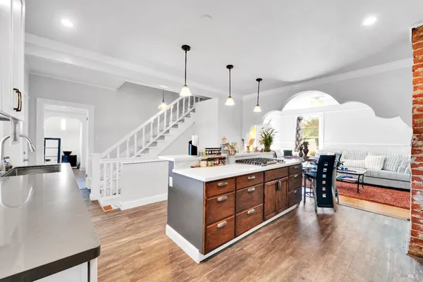a large kitchen with stainless steel appliances granite countertop a stove and a view of living room