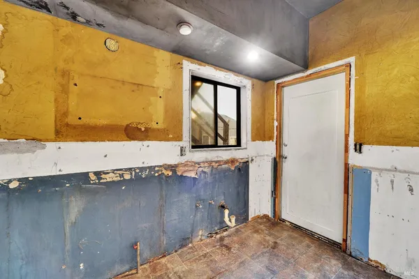 a view of a kitchen with stainless steel appliances granite countertop a stove and a window