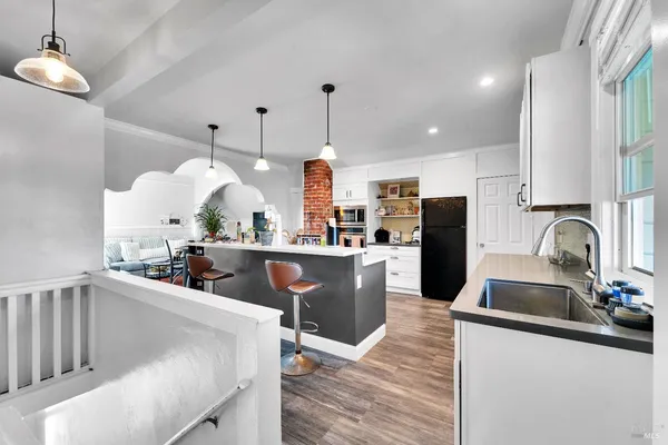 a kitchen with stainless steel appliances kitchen island granite countertop a sink a stove and a refrigerator