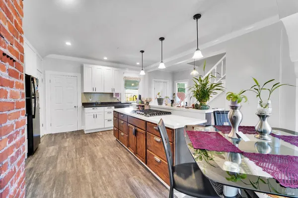 a kitchen with stainless steel appliances kitchen island granite countertop a stove a sink and a refrigerator