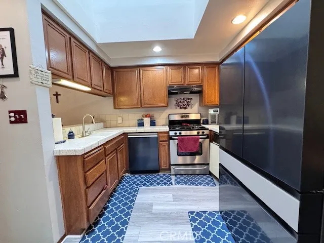 a kitchen with stainless steel appliances kitchen island granite countertop a sink stove and cabinets