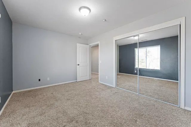 an empty room with a cabinet and mirror