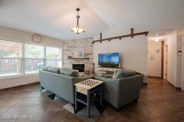 a living room with furniture a fireplace and a flat screen tv
