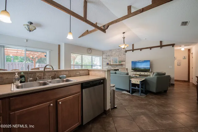 a kitchen with sink a counter top space appliances and a window