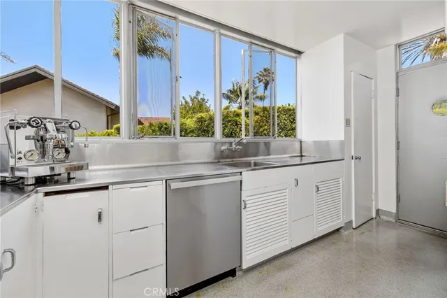 a kitchen with white cabinets and sink