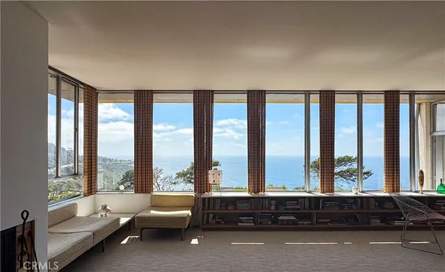 a living room with furniture and floor to ceiling windows