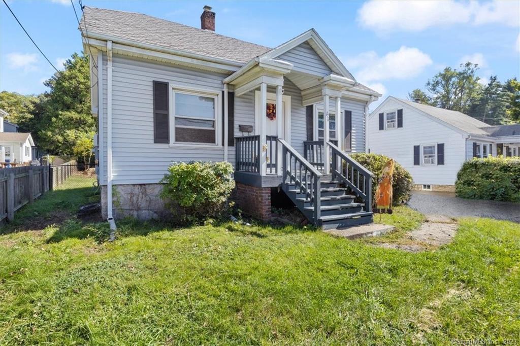 a view of a house with wooden fence and a yard