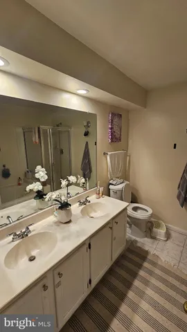 a spacious bathroom with a double vanity sink and a mirror