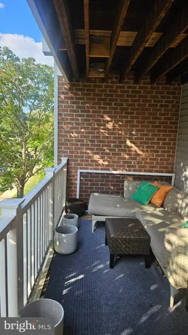 a view of a patio with couches chairs and wooden floor