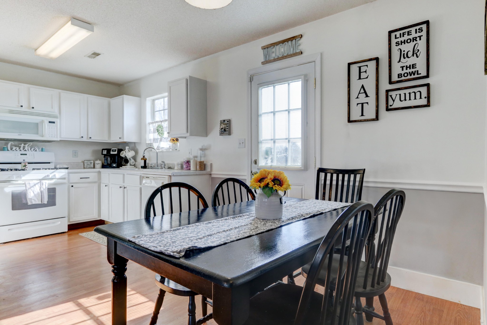 7832 Ralph Youmans Road Corryton, TN 37721 - Photo 20 of 22 a kitchen with granite countertop a dining table chairs and white cabinets