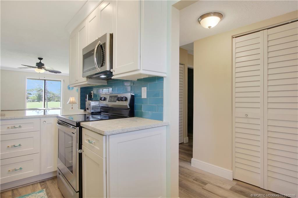 5323 Southeast Miles Grant Road, Unit 206 Stuart, FL 34997 - Photo 6 of 20 a kitchen with stainless steel appliances granite countertop white cabinets and window